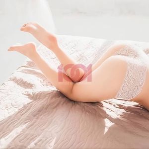 A close-up of legs and feet in a delicate setting, featuring soft fabric and light colors.