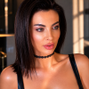A close-up of a woman with glossy lips, a choker, and a sleek hairstyle, in soft lighting.