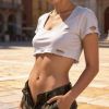 Giovane donna con capelli corti, indossa una maglietta strappata e pantaloni mimetici, in una piazza soleggiata.