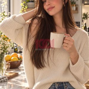 Una giovane donna sorride mentre tiene una tazza in un'accogliente cucina luminosa.